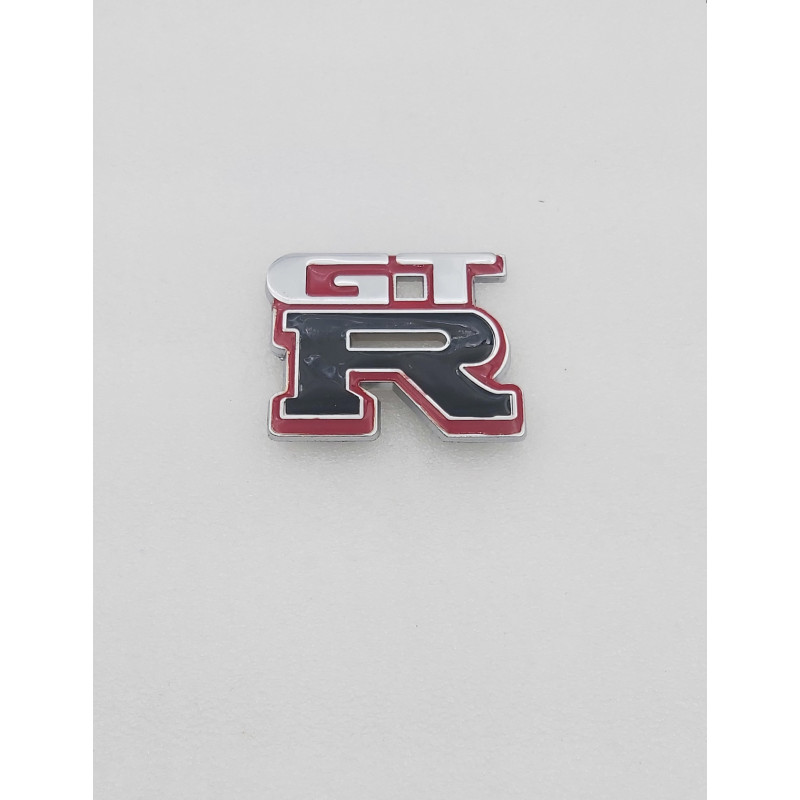 EMBLEMA DE PARRILLA NISSAN GTR BLANCO Y NEGRO Y BORDE ROJO